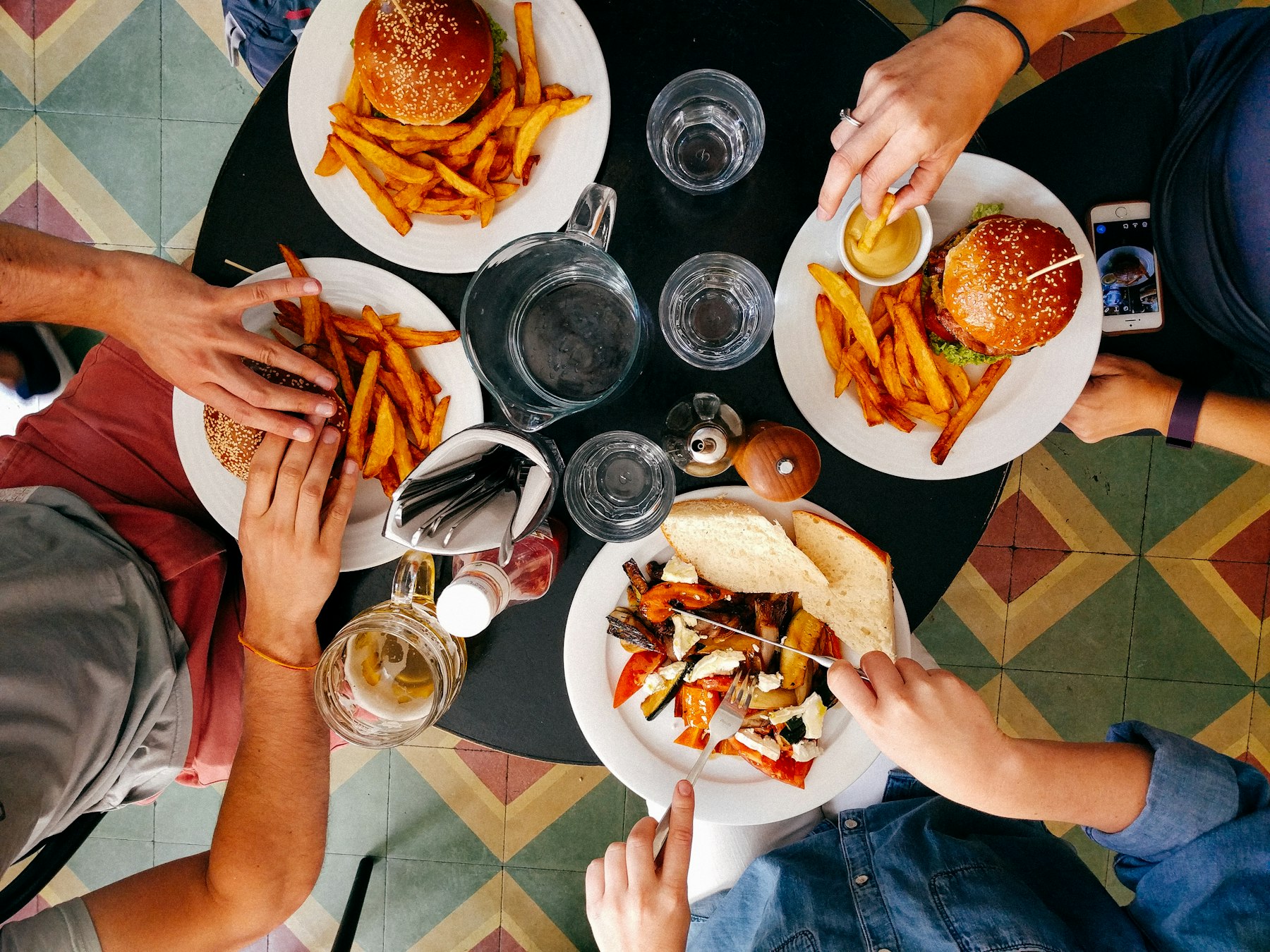 Burgers et frites vus du dessus, partagés à table